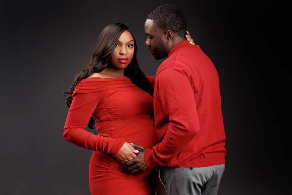 maternity session of a couple in red outfits